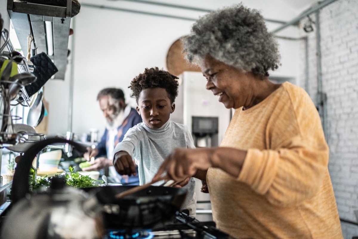 Grandson helping his grandmother cooking at home