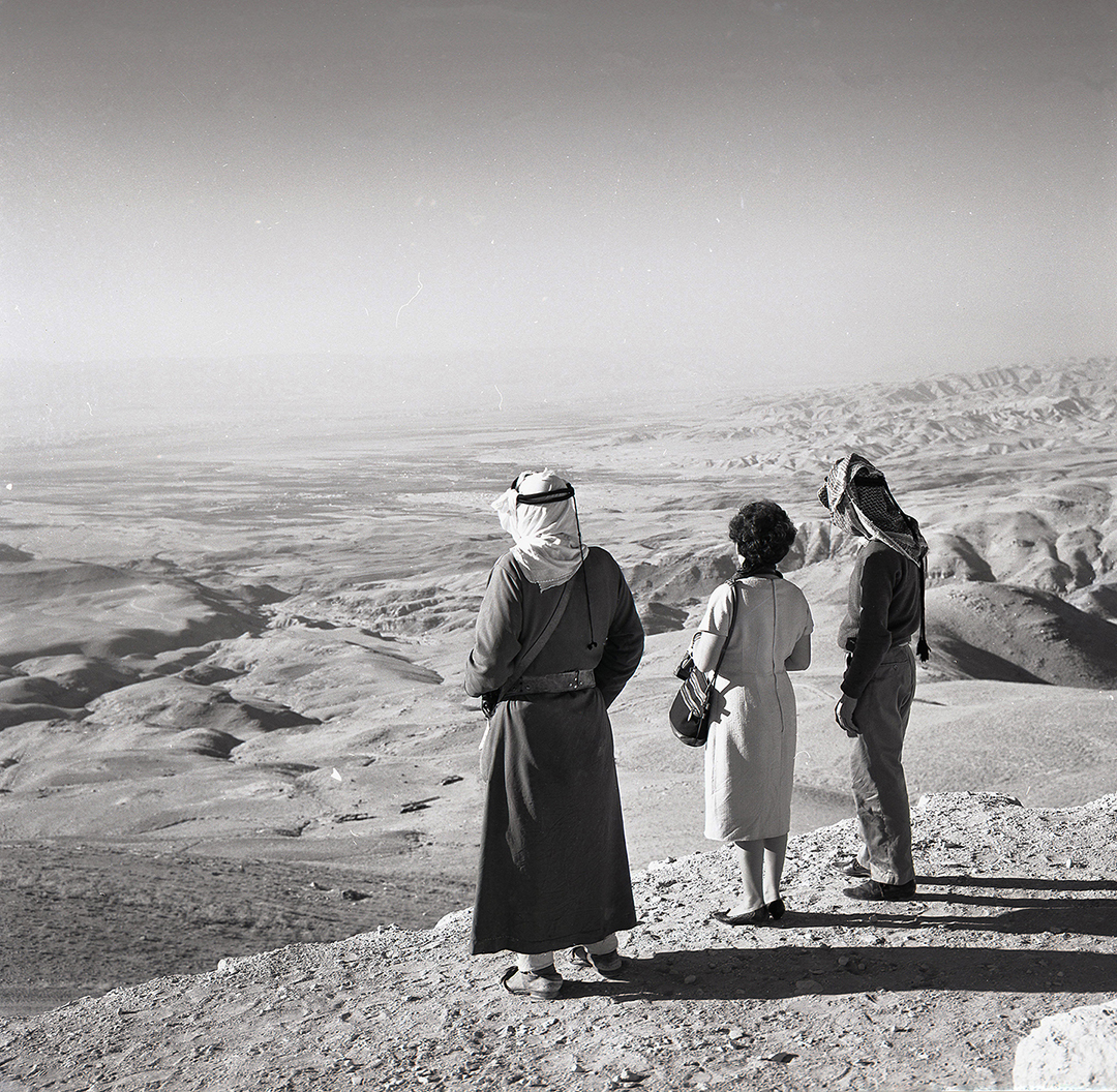 a woman and two men look at a desert in Jordan