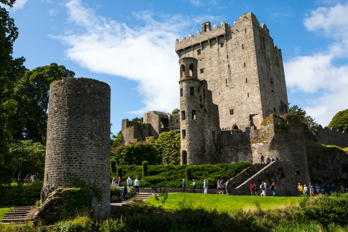 medieval castle in ireland with tourists on its lawn