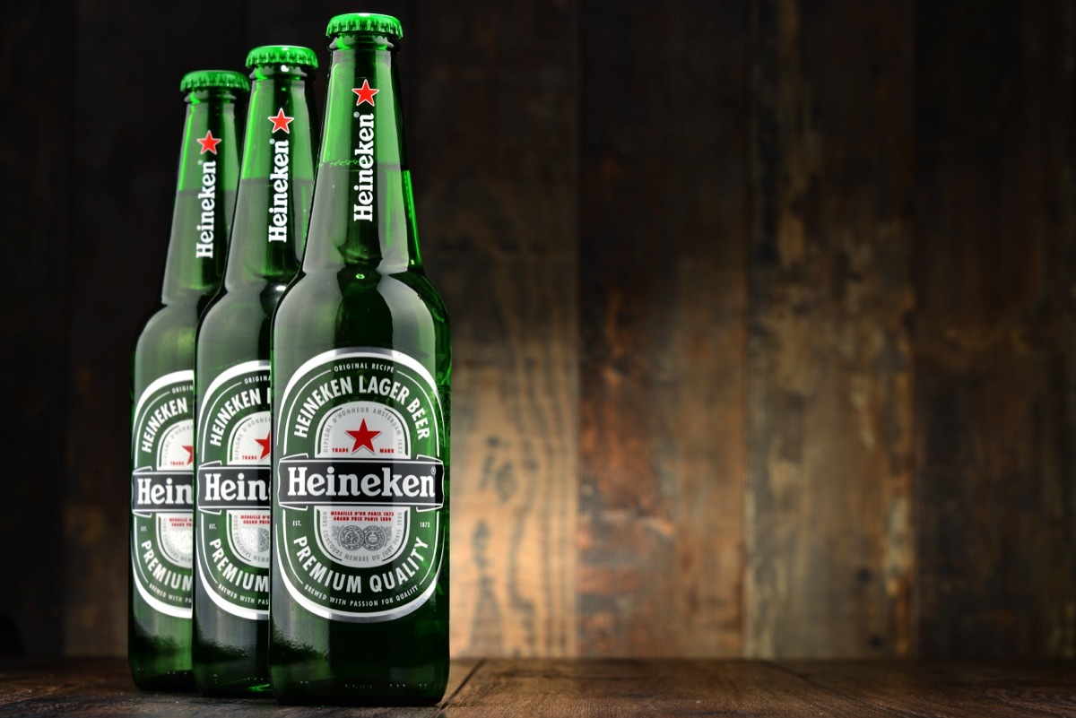 three green bottles of heineken beer on wooden background