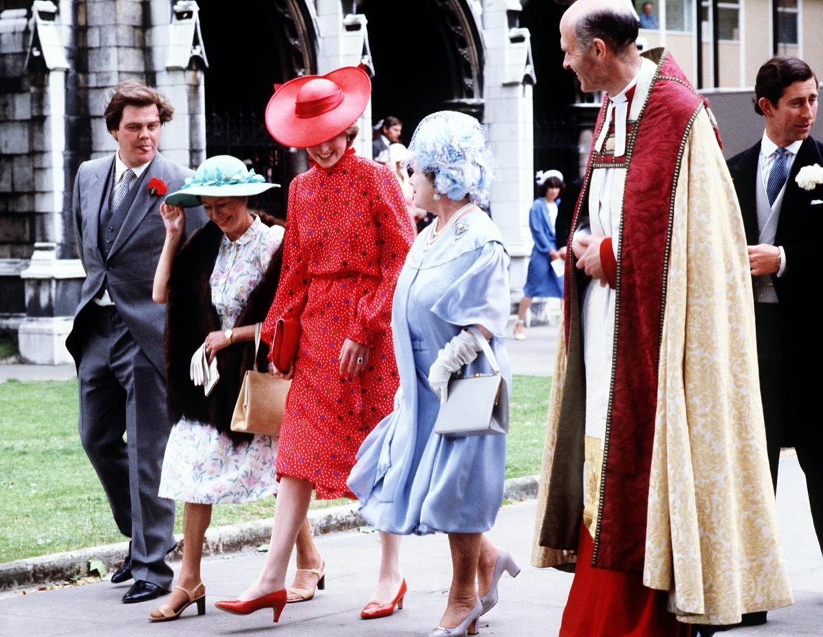 Princess Diana wearing red dress and hat at the Soames Wedding in 1981