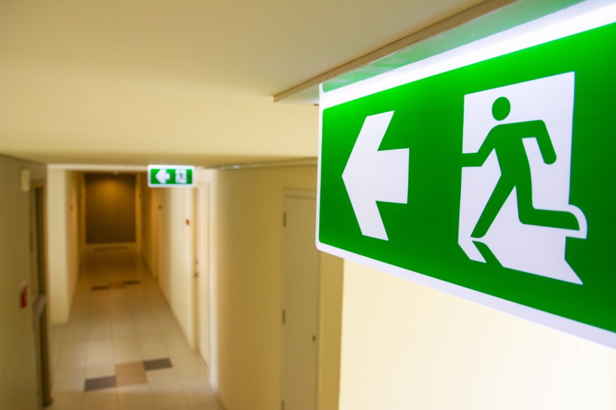 Fire exit sign at the corridor in building.