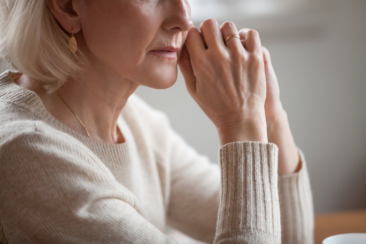 older woman sits with elbows on table, disappointed, divorce over 40, finding love again