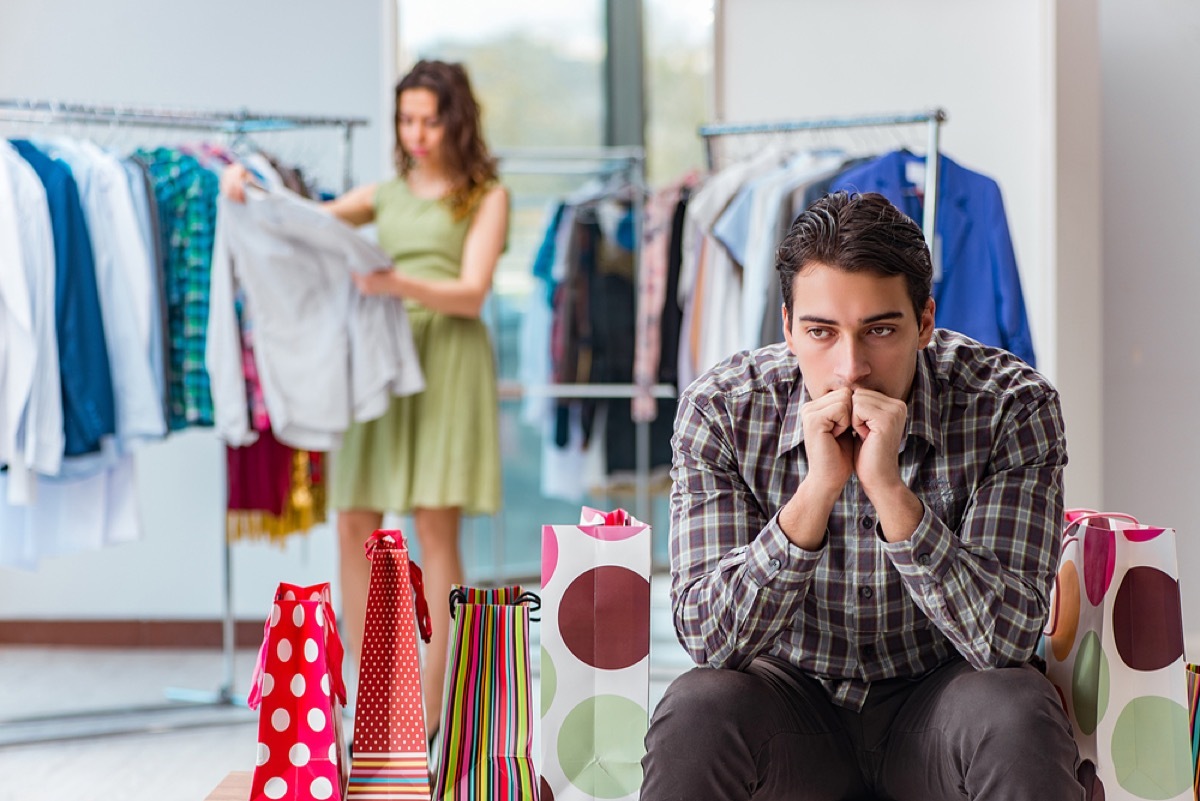 woman trying on clothes with bored spouse, things you should never say to your spouse