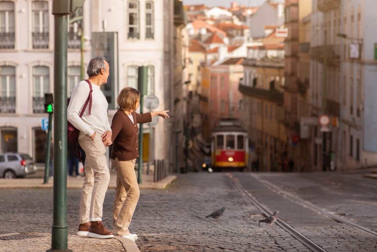 retired couple walking on street in portugal