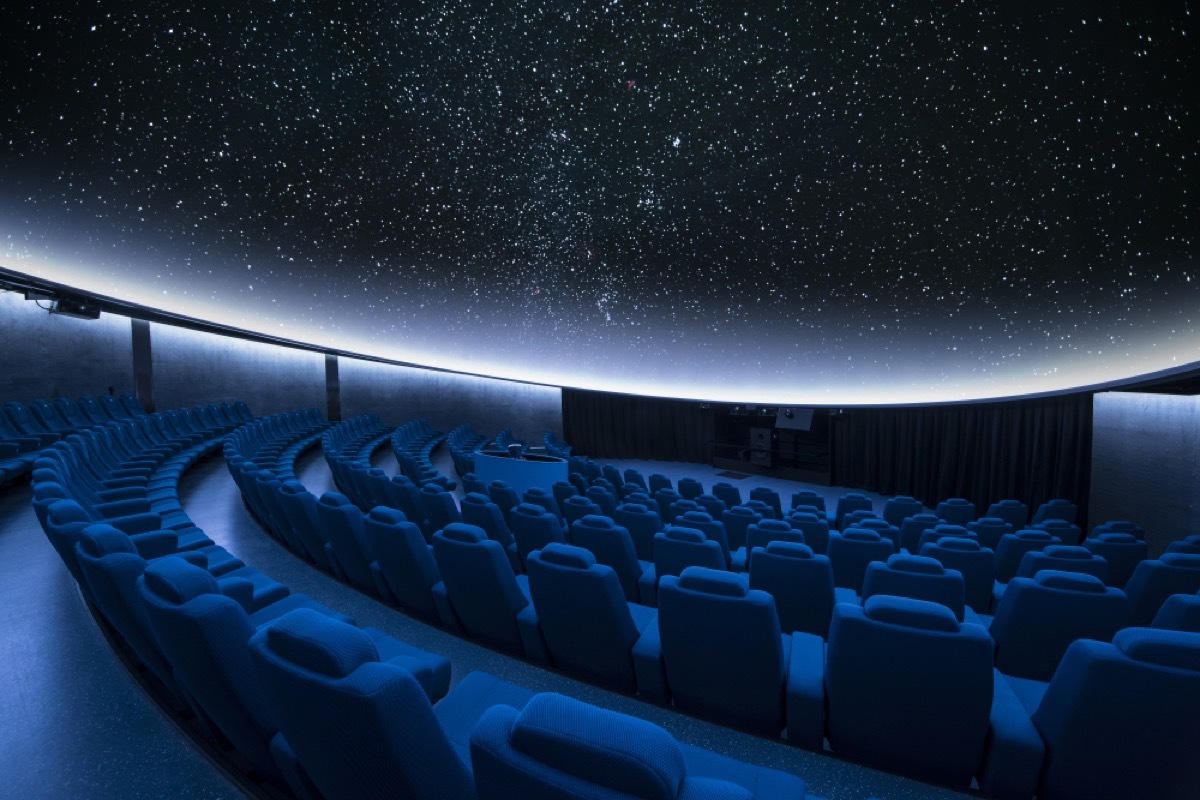 interior of planetarium shows empty seats with stars projection