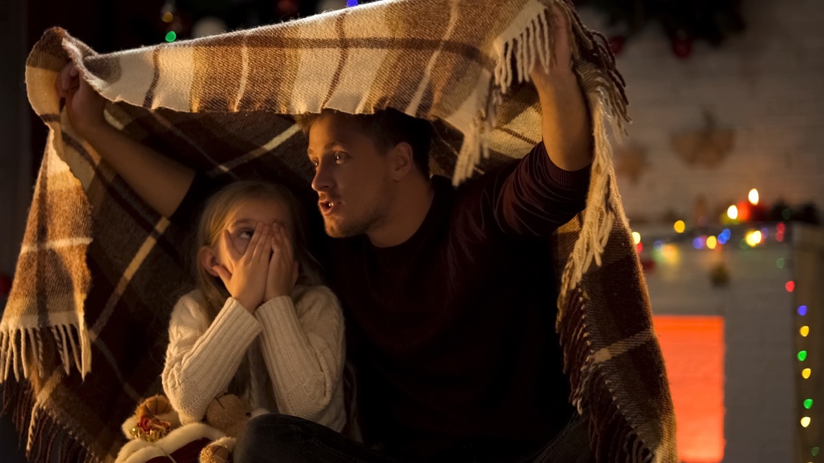 dad telling scary christmas stories to daughter