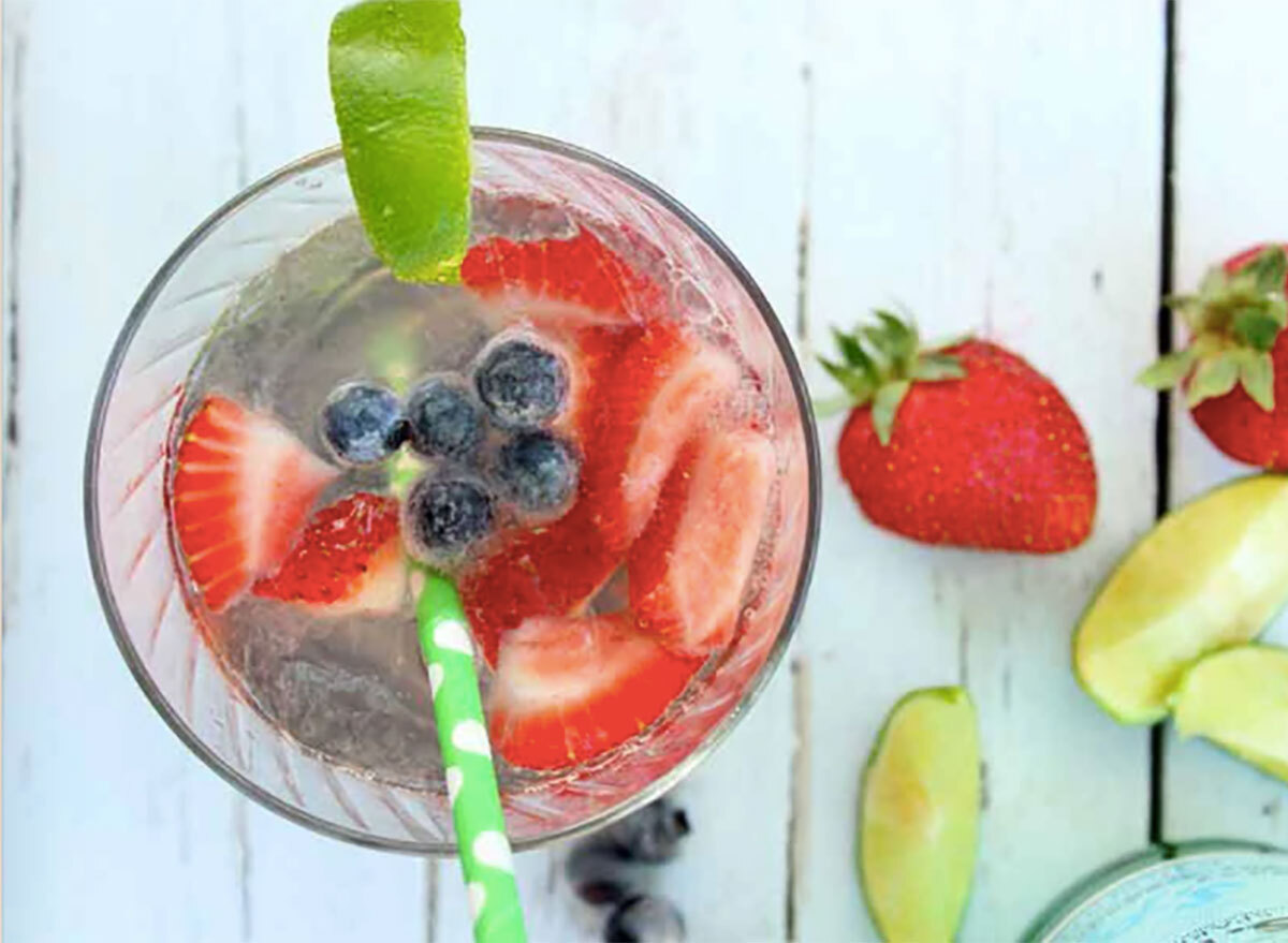 skinny summer cocktail with strawberries and lime wedges