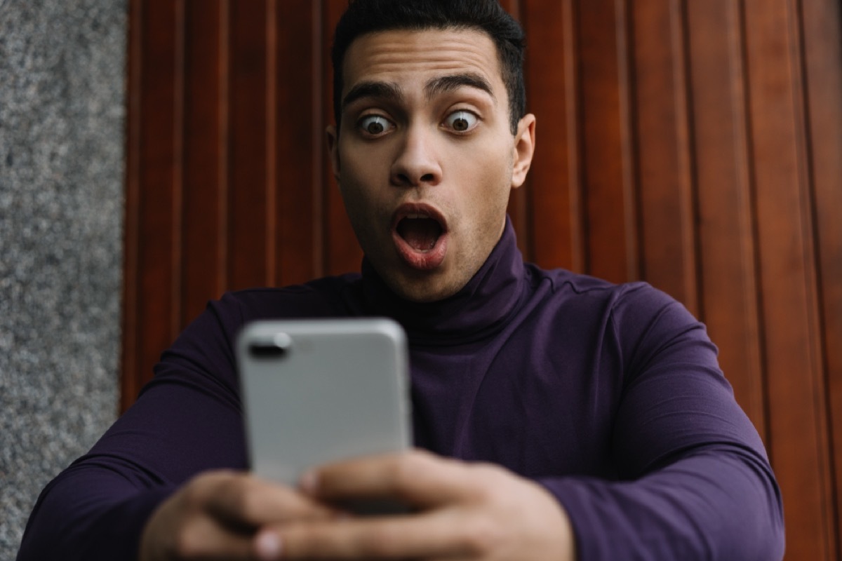 man of color looks shocked at phone