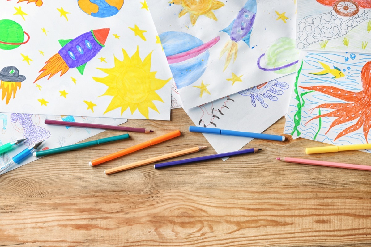 children's art and colored pencils on wooden desk, home upgrades