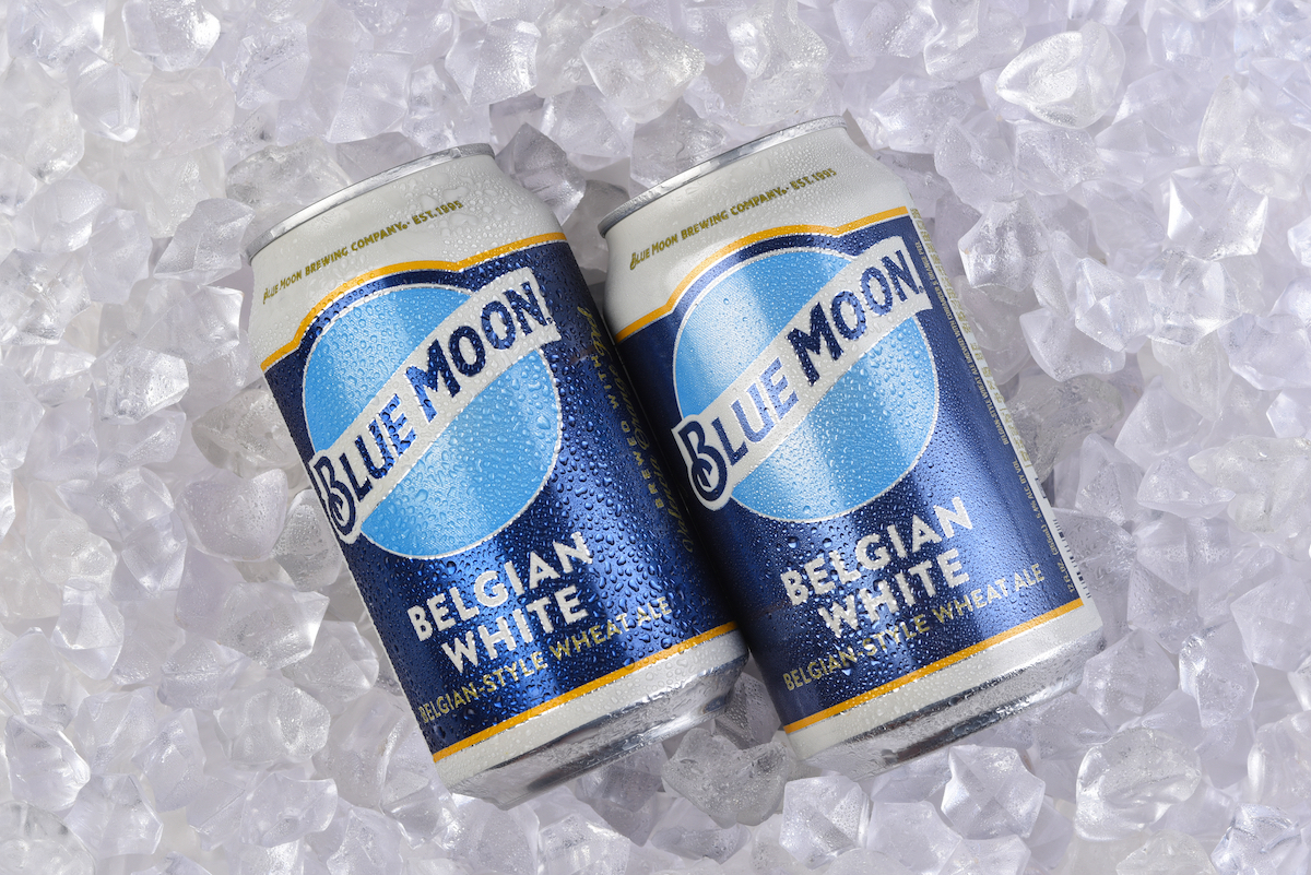Two cans of Blue Moon Belgian White Ale in a bed of Ice.