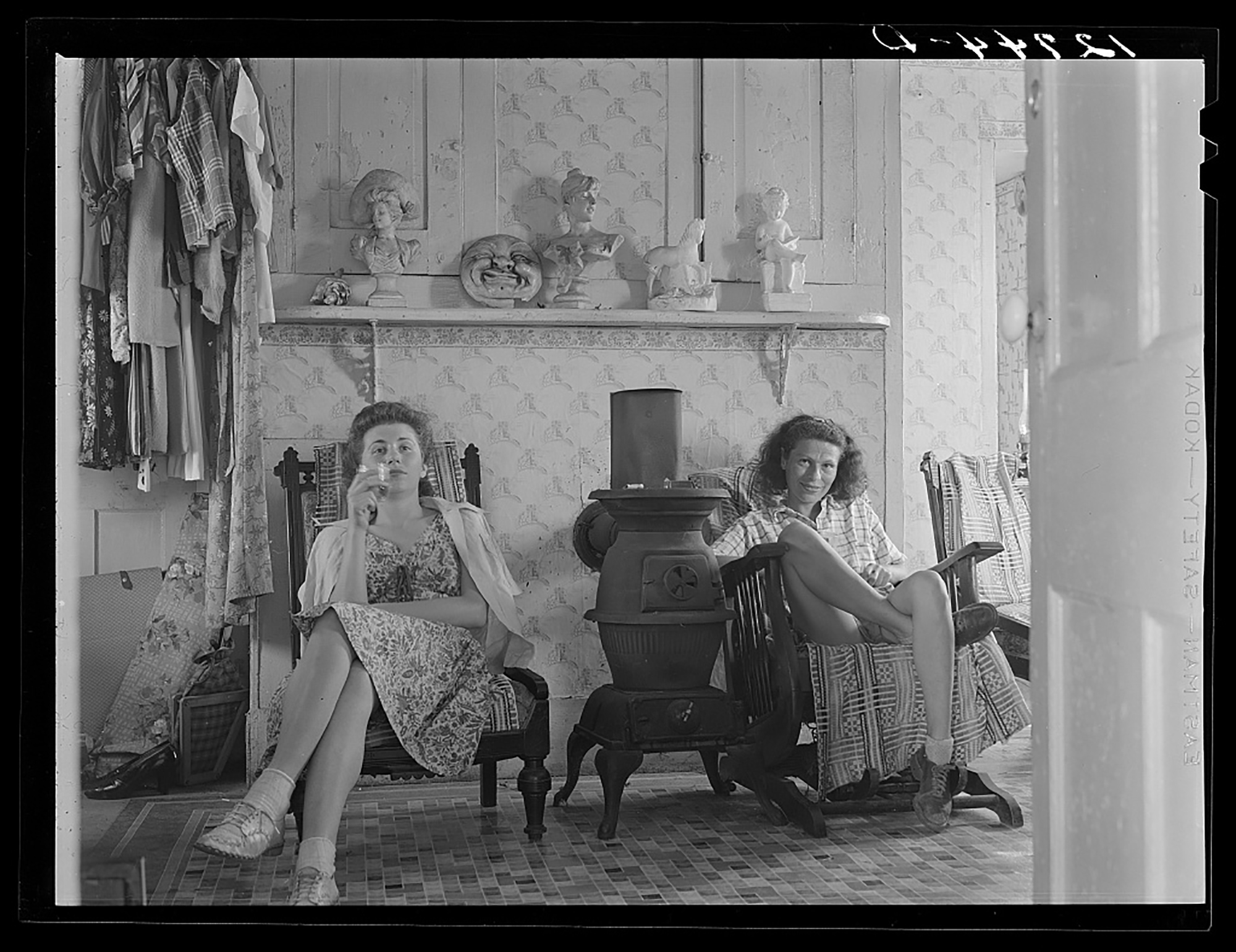 two women sit inside a home in the 1940s