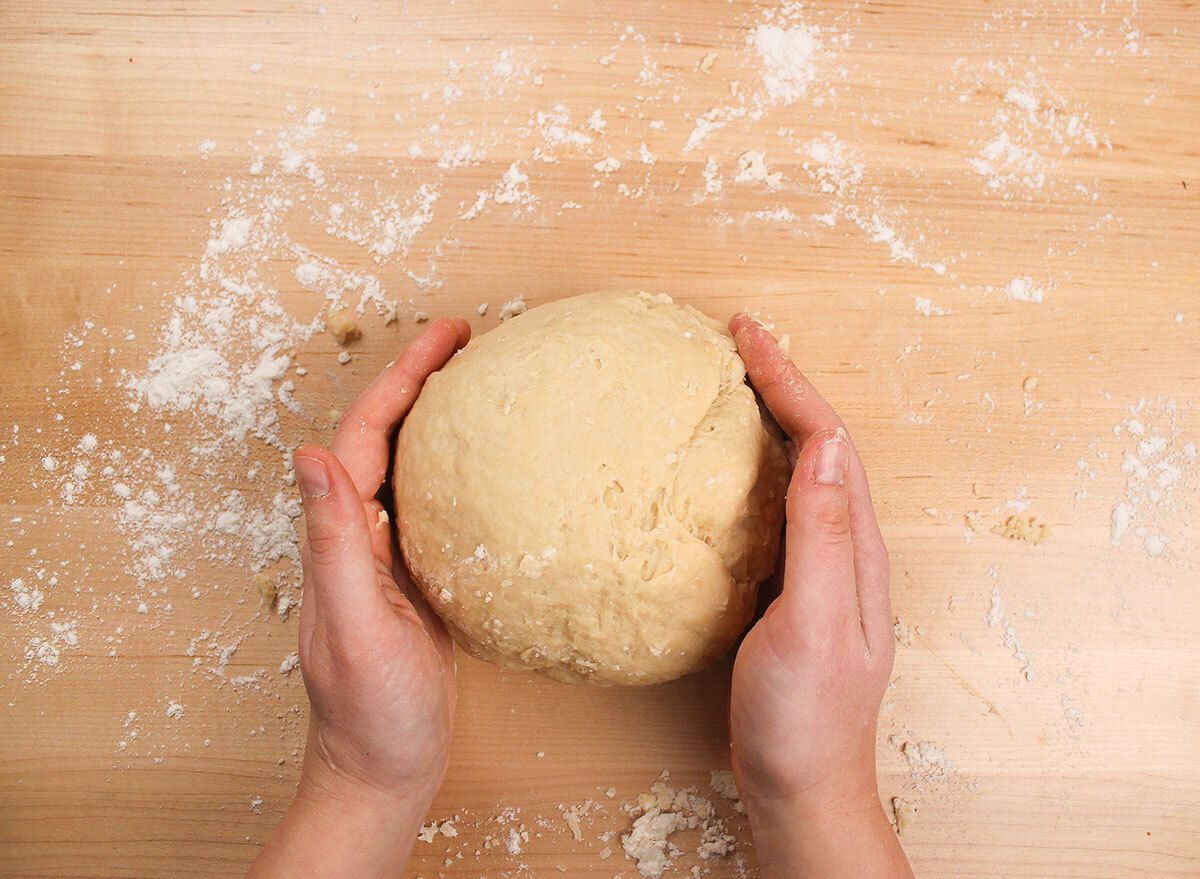 shaping a dough ball on a floured surface