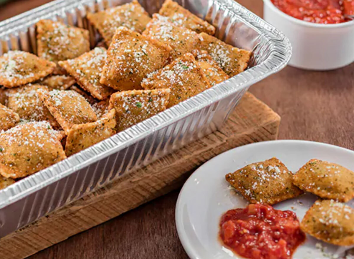 olive garden toasted beef and pork ravioli in serving tray with plate of three ravioli and tomato sauce