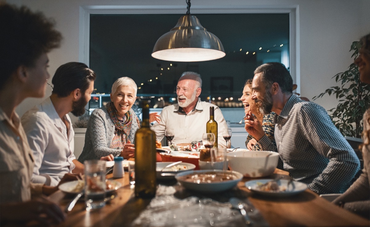 Closeup front view of a family having a Christmas breakfast. They are having some traditional roast, gravy and vegetables and also some vegetarian food. Right now they are toasting with wine. There are three generations at the table.