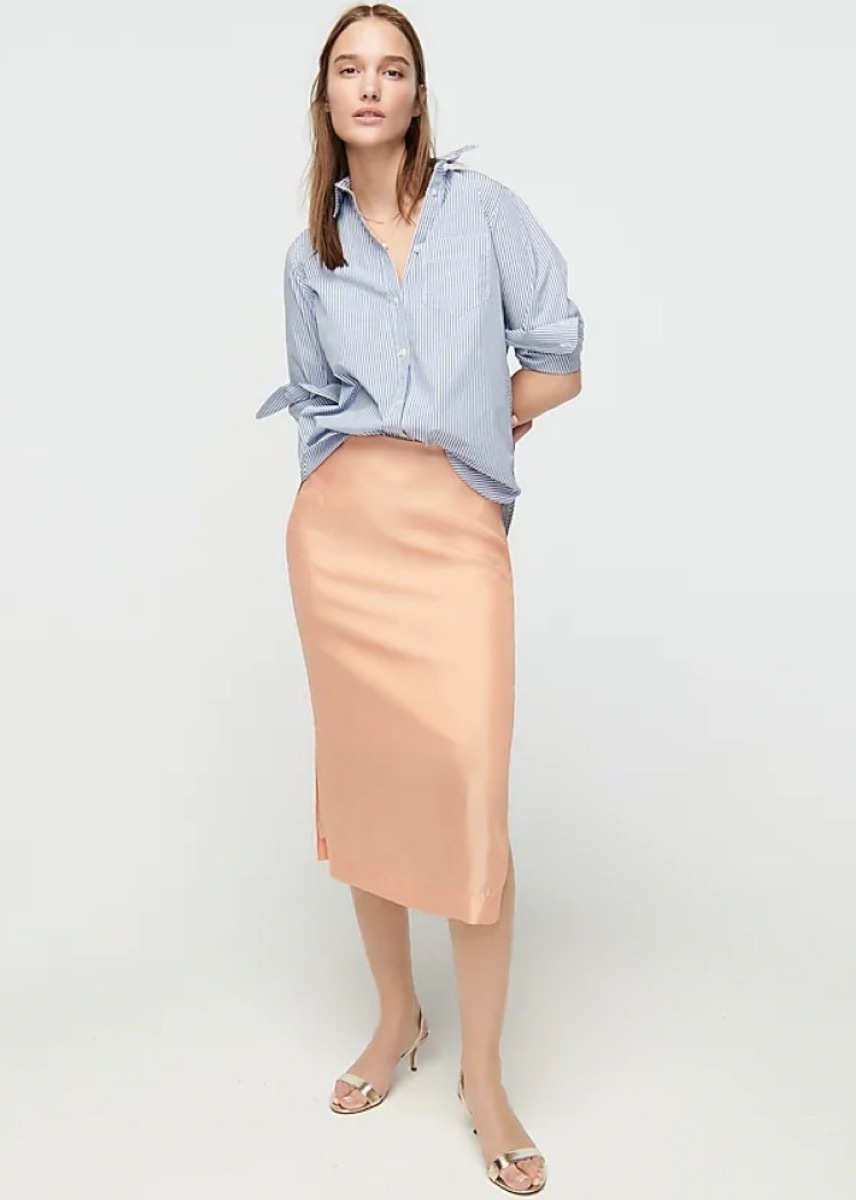 young white woman in orange silk midi skirt and blue top