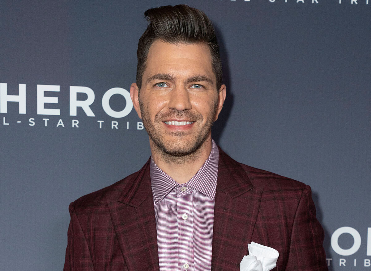 andy grammer on step and repeat wearing purple shirt and white pocket square