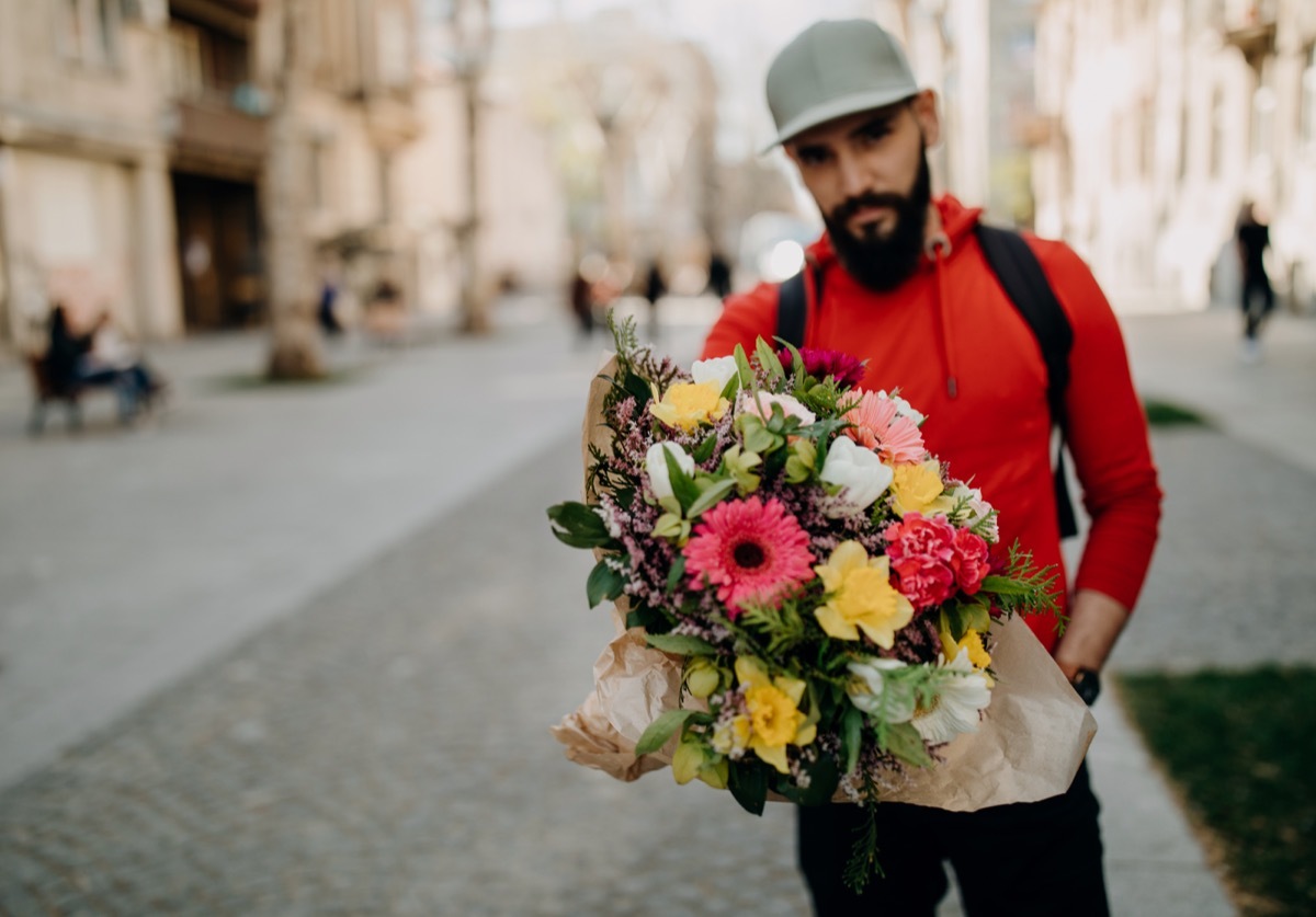 Young man carrying flower bouquet