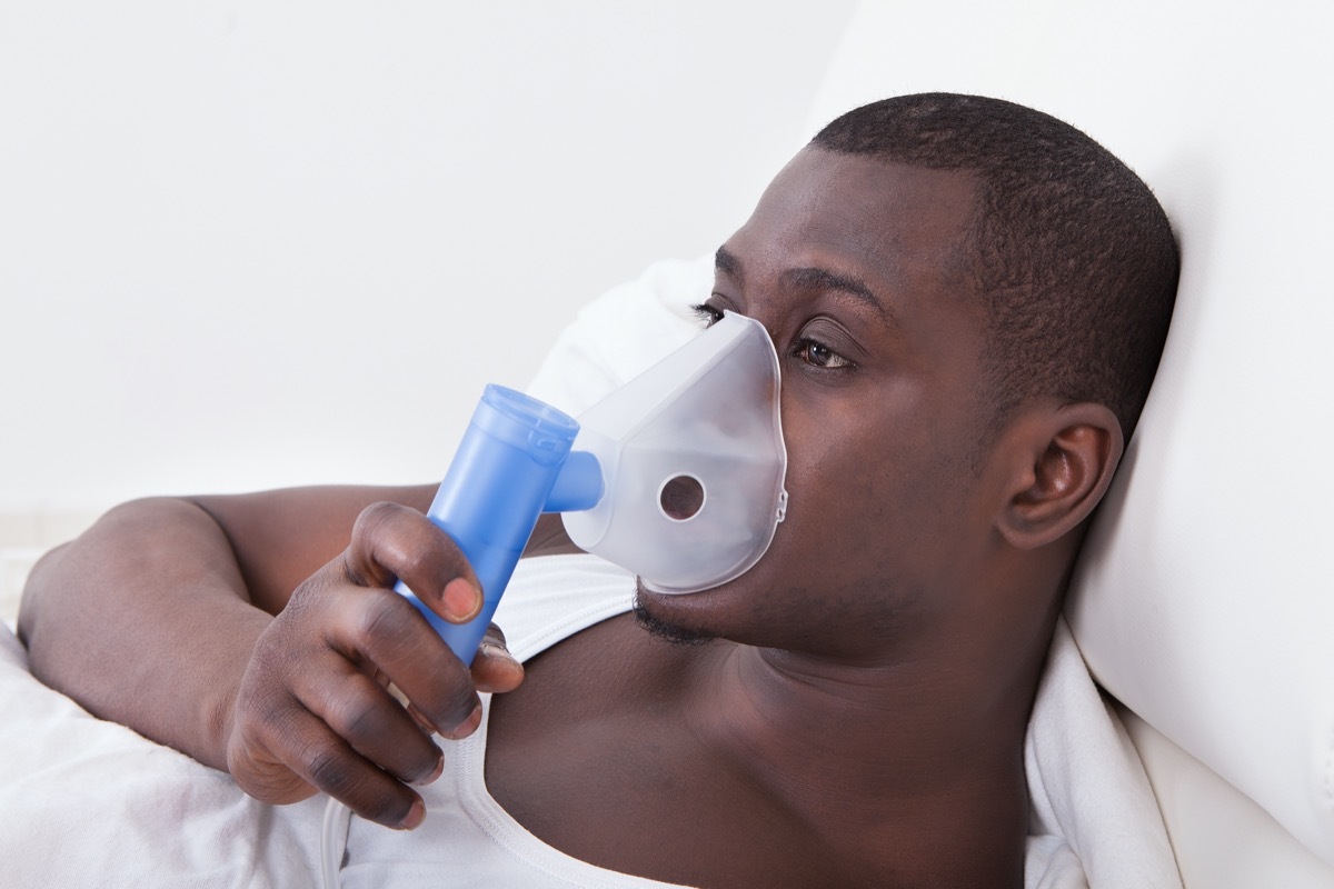Young Man Doing Inhalation Through Oxygen Mask