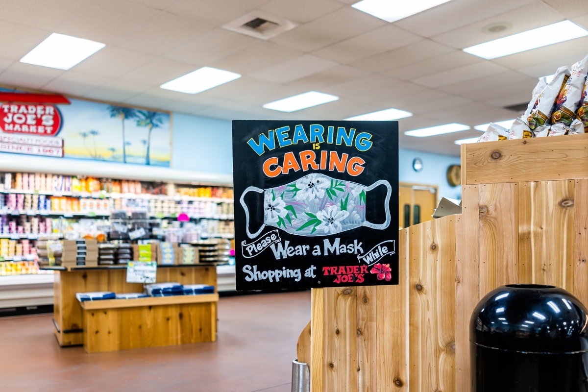 Reston, USA - July 23, 2020: Wearing is caring sign inside Trader Joe's grocery shop store during coronavirus outbreak pandemic with request to wear face mask covering when shopping