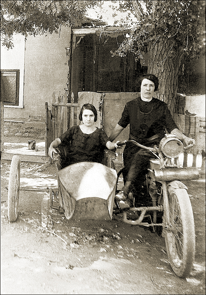 two women ride a motorcycle and sidecar