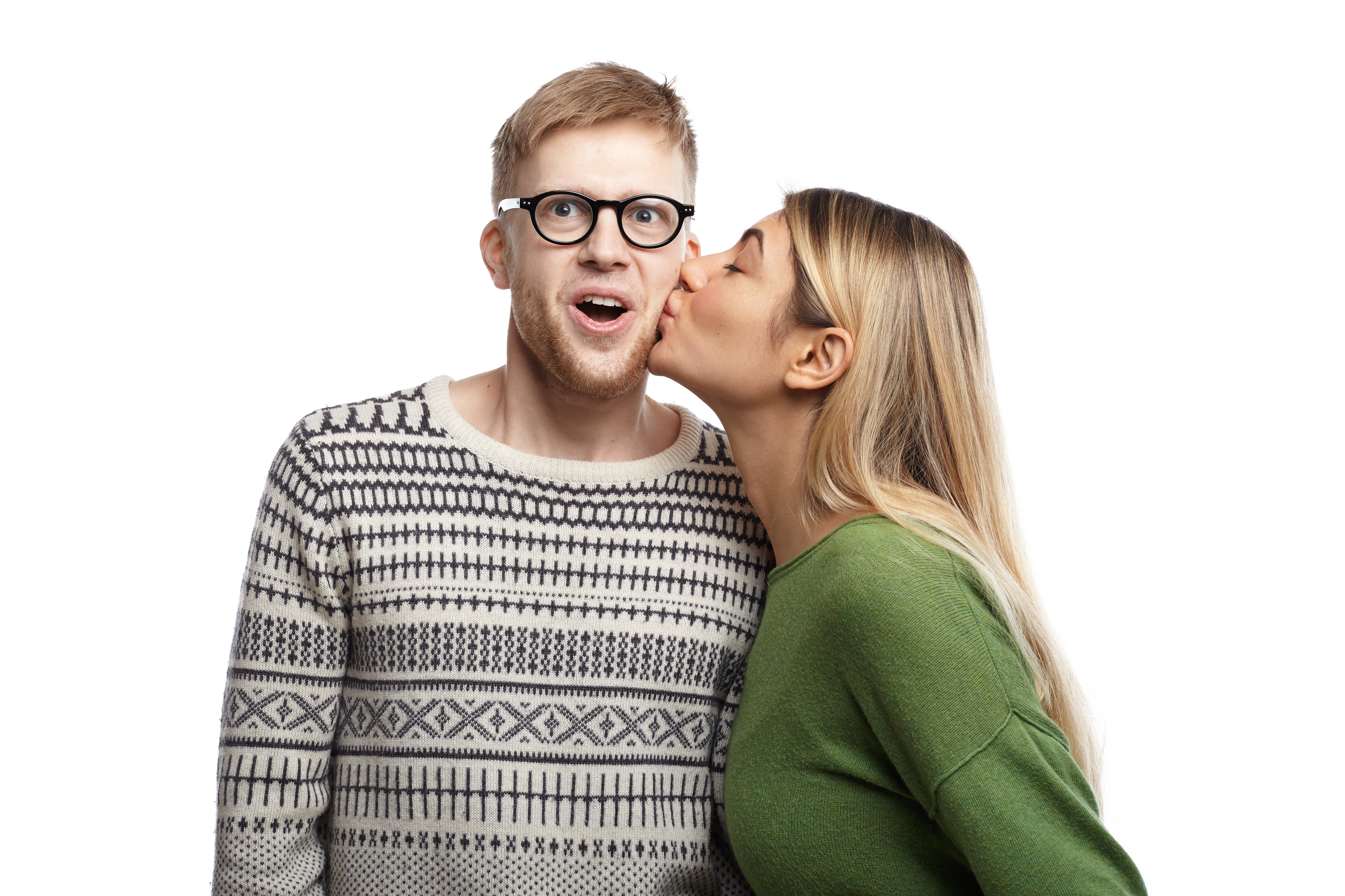 man looking surprised as woman kisses him on cheek
