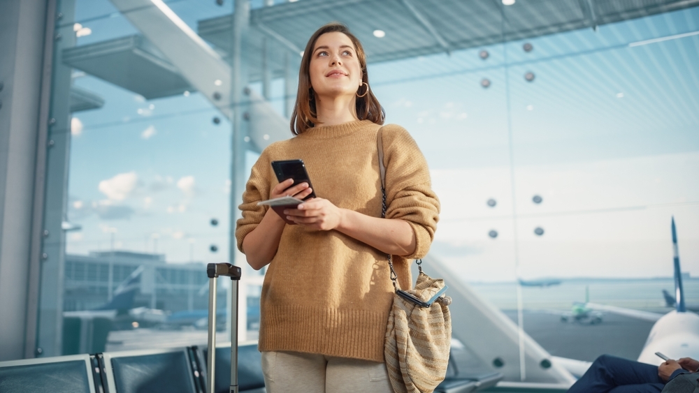 A woman holding her passport and boarding pass in an airport