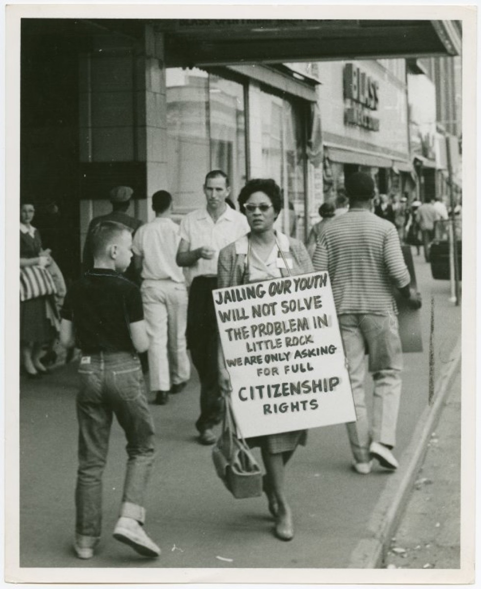 daisy bates protesting outside with sign