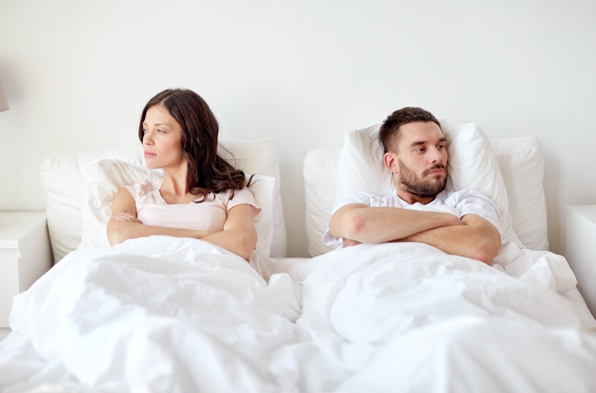 upset white couple in bed