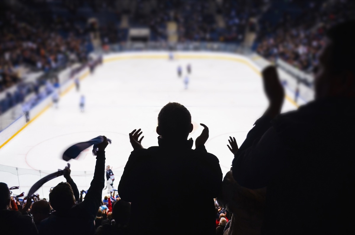 fans cheering ice hockey game at sports venue