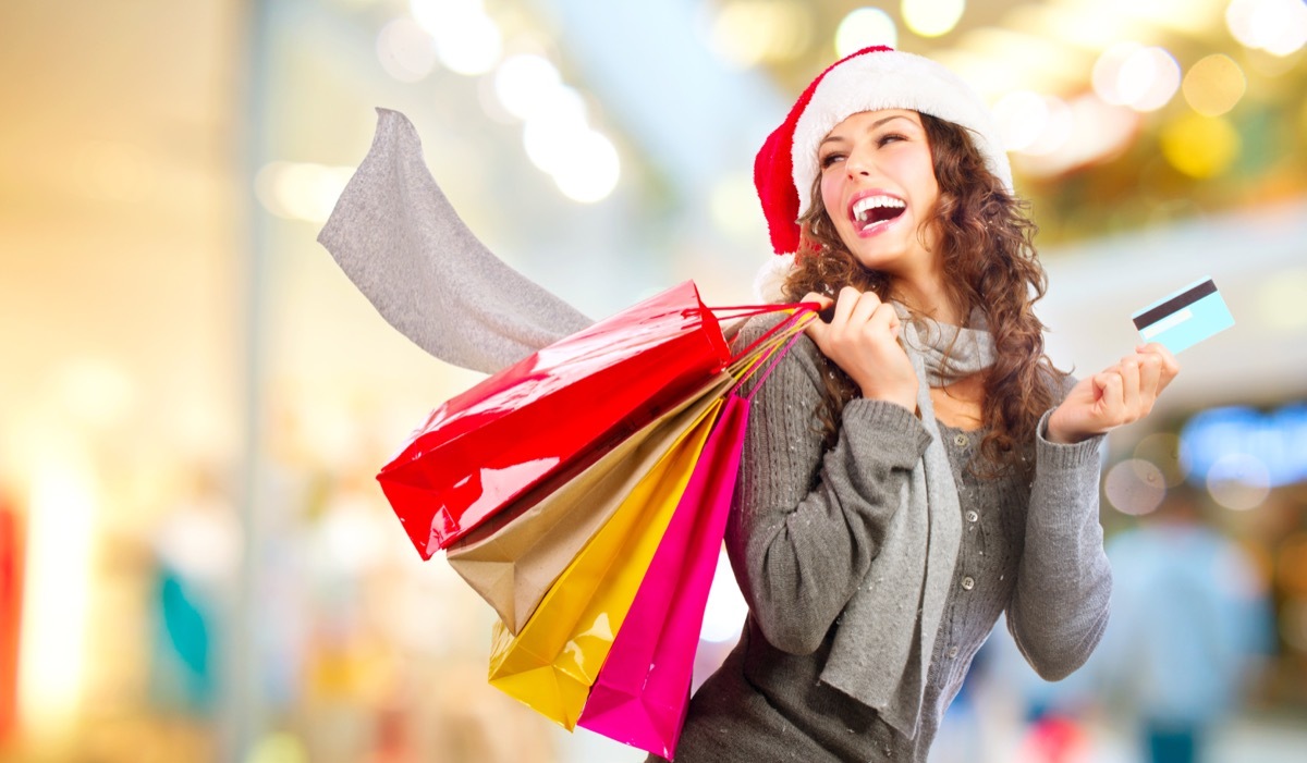 happy woman with shopping bags and credit card