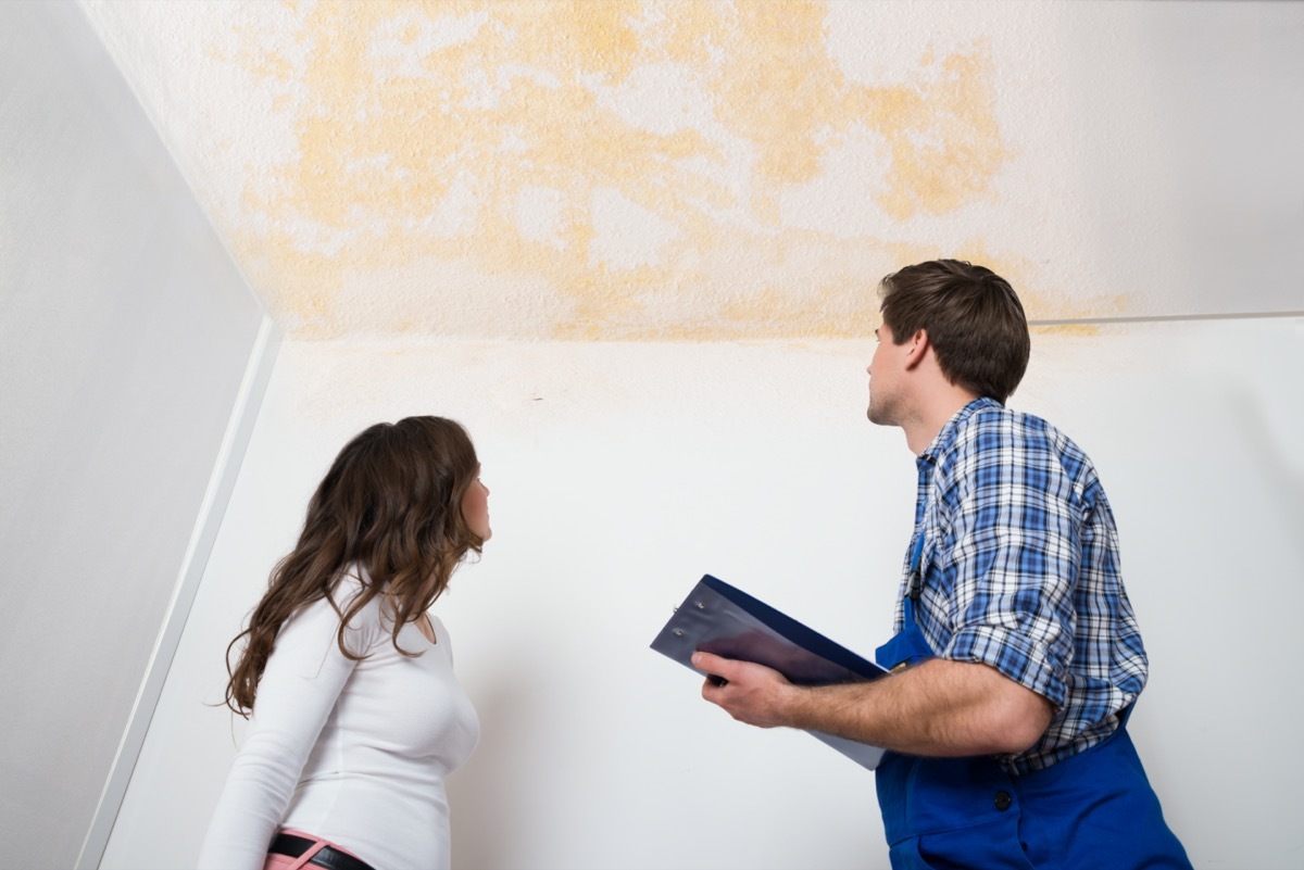 white woman and man looking at stained ceiling