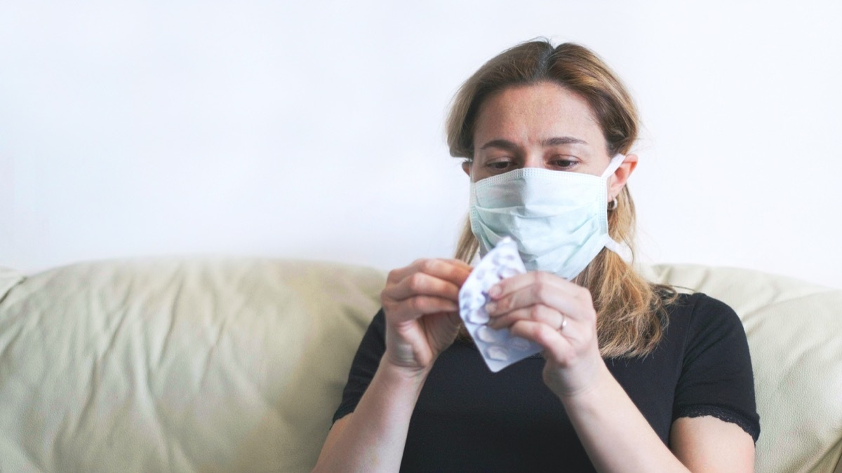 woman wearing mask, sick person opening medicine