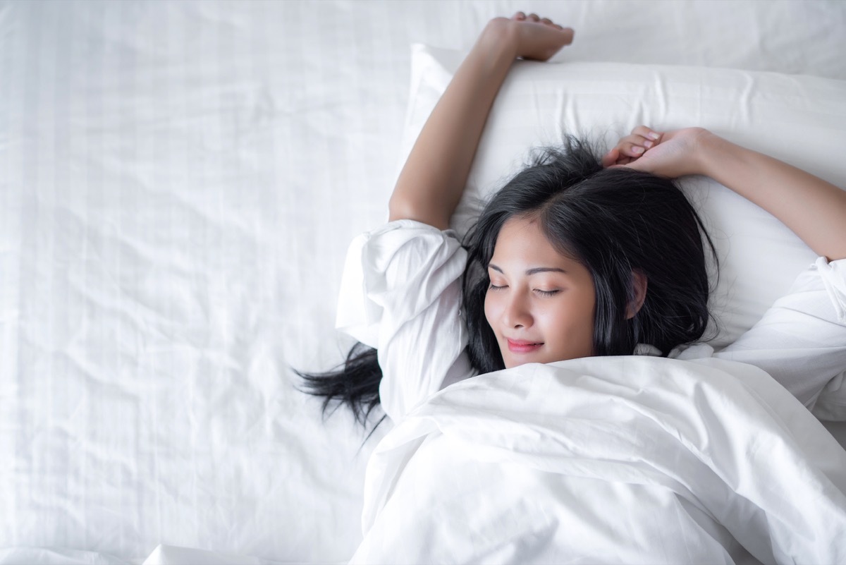 young asian woman waking up with a smile