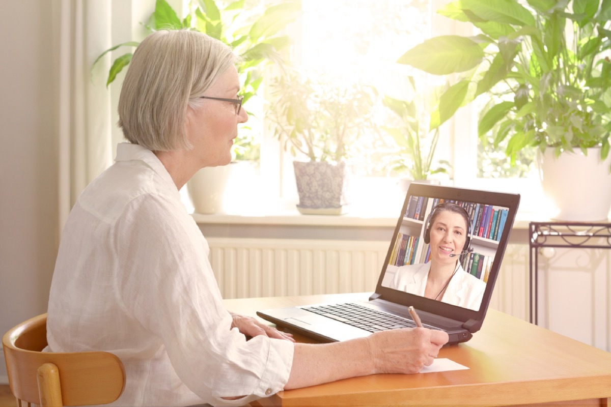 older white woman video chatting with doctor on laptop