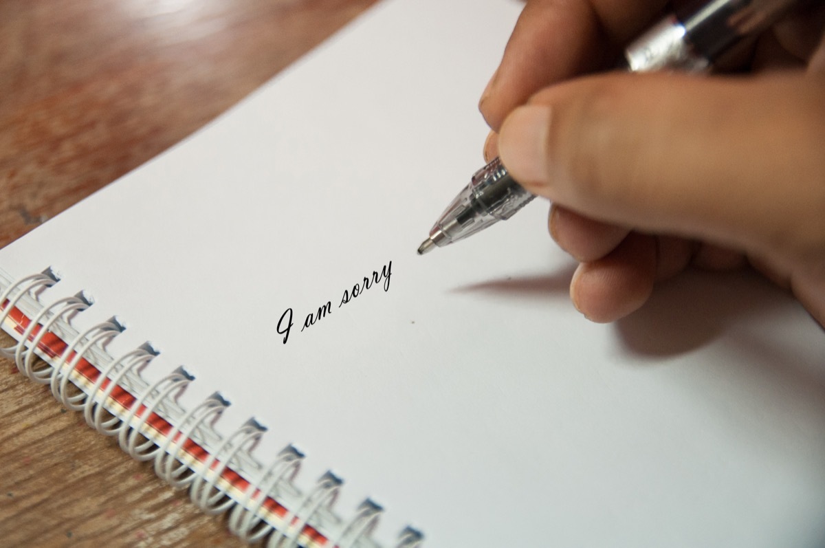 person writing condolence messages with pen and paper