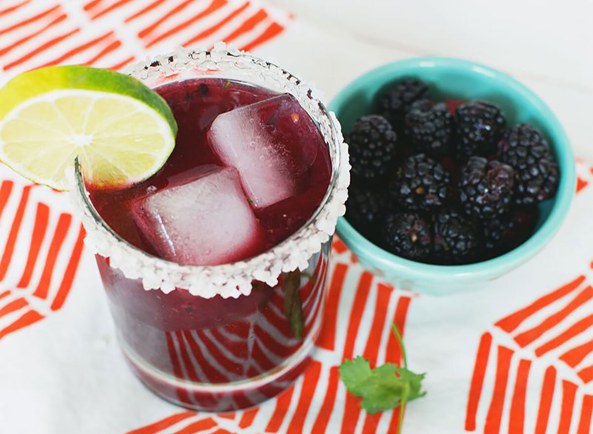 blackberry cilantro margarita in cup with blackberries on side