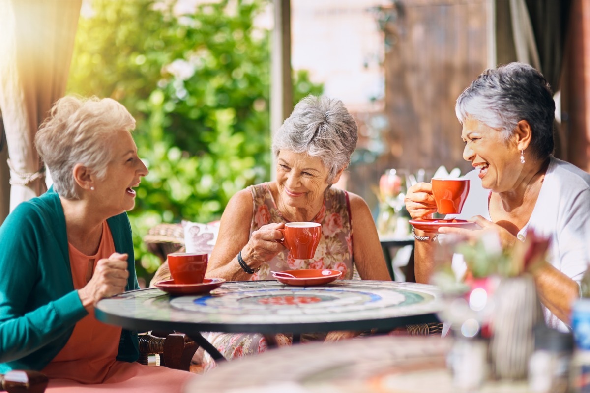three mature women having coffee together at the cafe