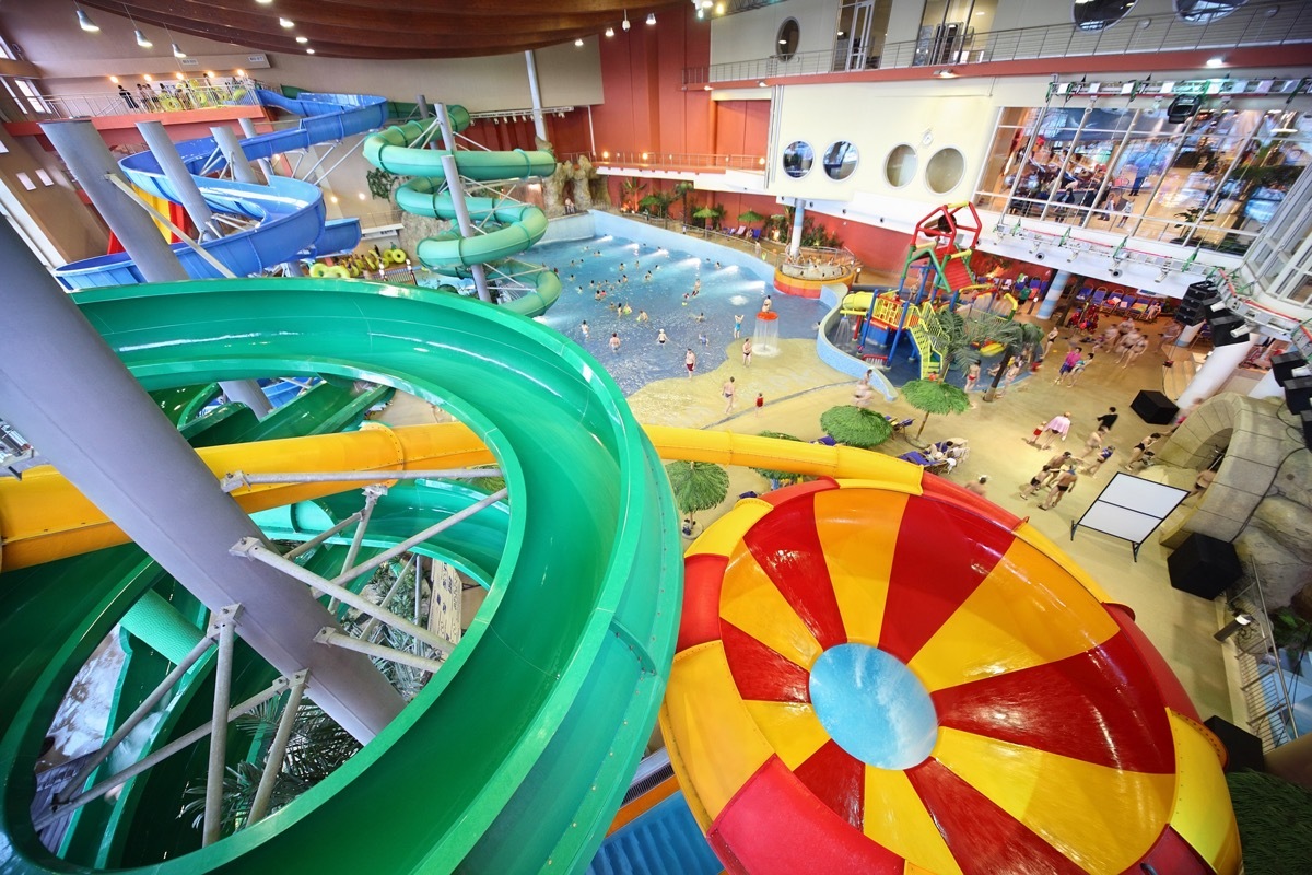 Large varicoloured chutes as spiral and pool in water park.