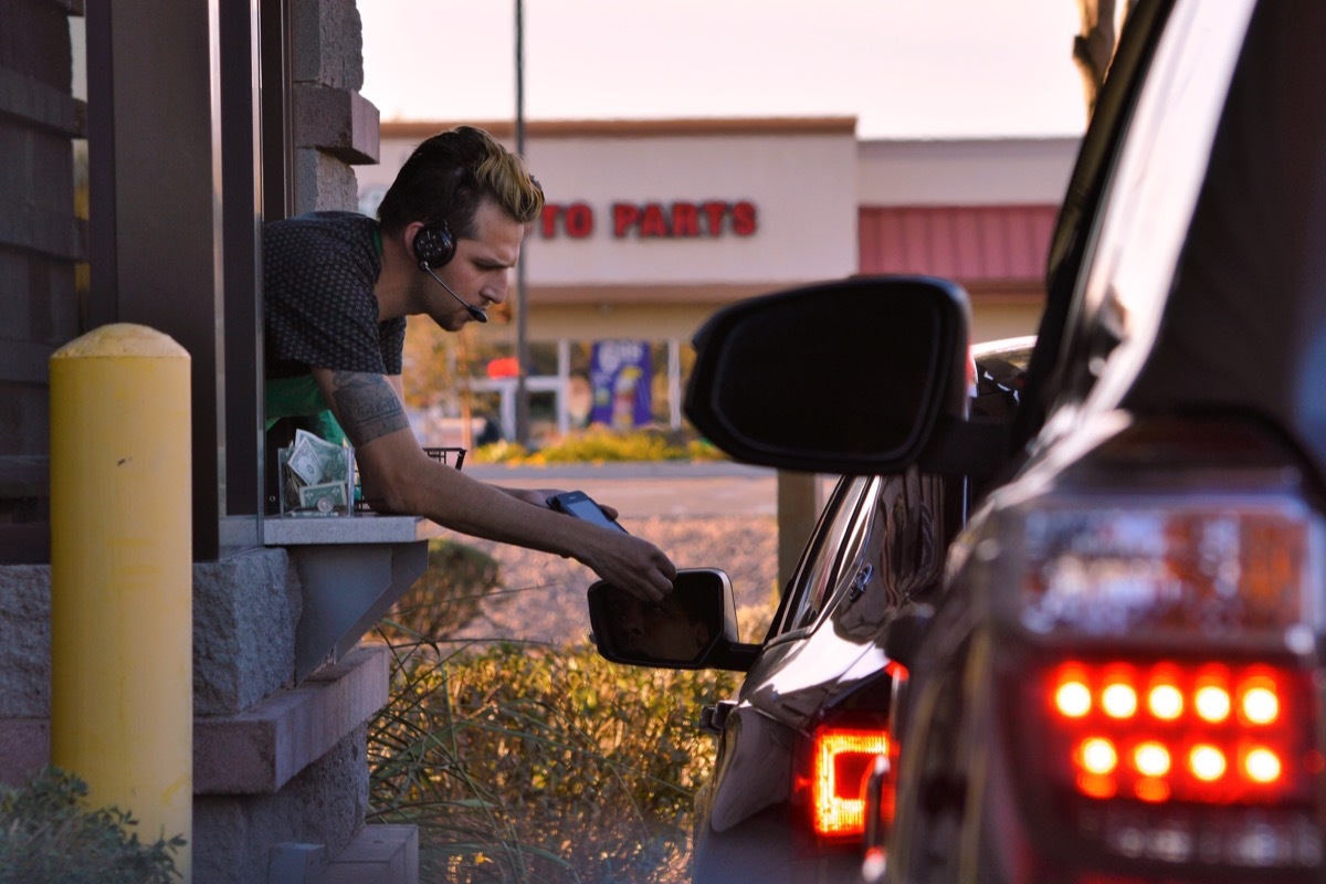 employee taking payment at a drive-thru
