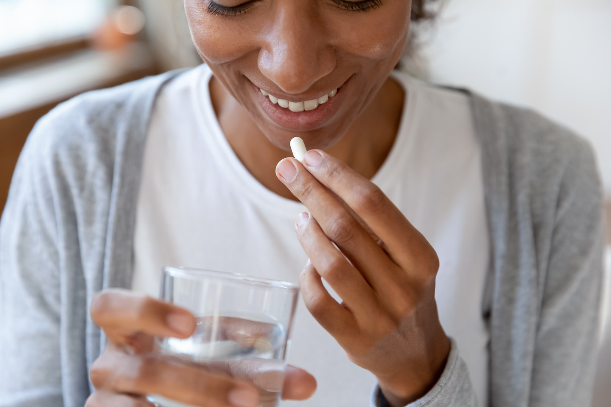 Woman taking medication with water. 