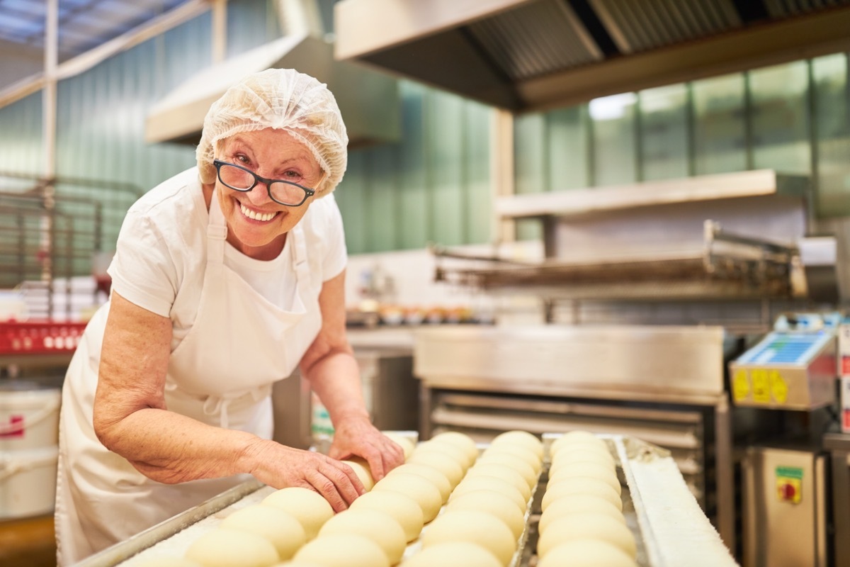 Happy senior woman working as a baker