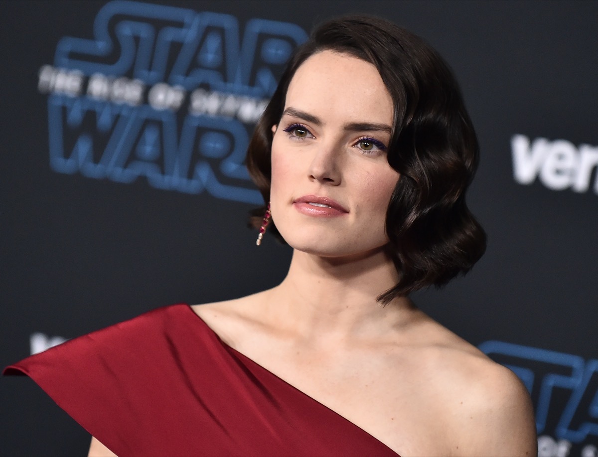 Daisy Ridley wears a red dress as the premiere of 
