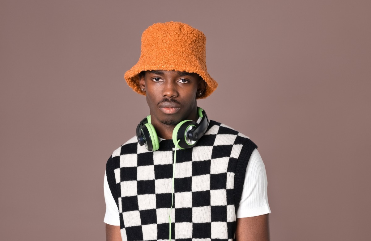 young black man in a checkered sweater vest