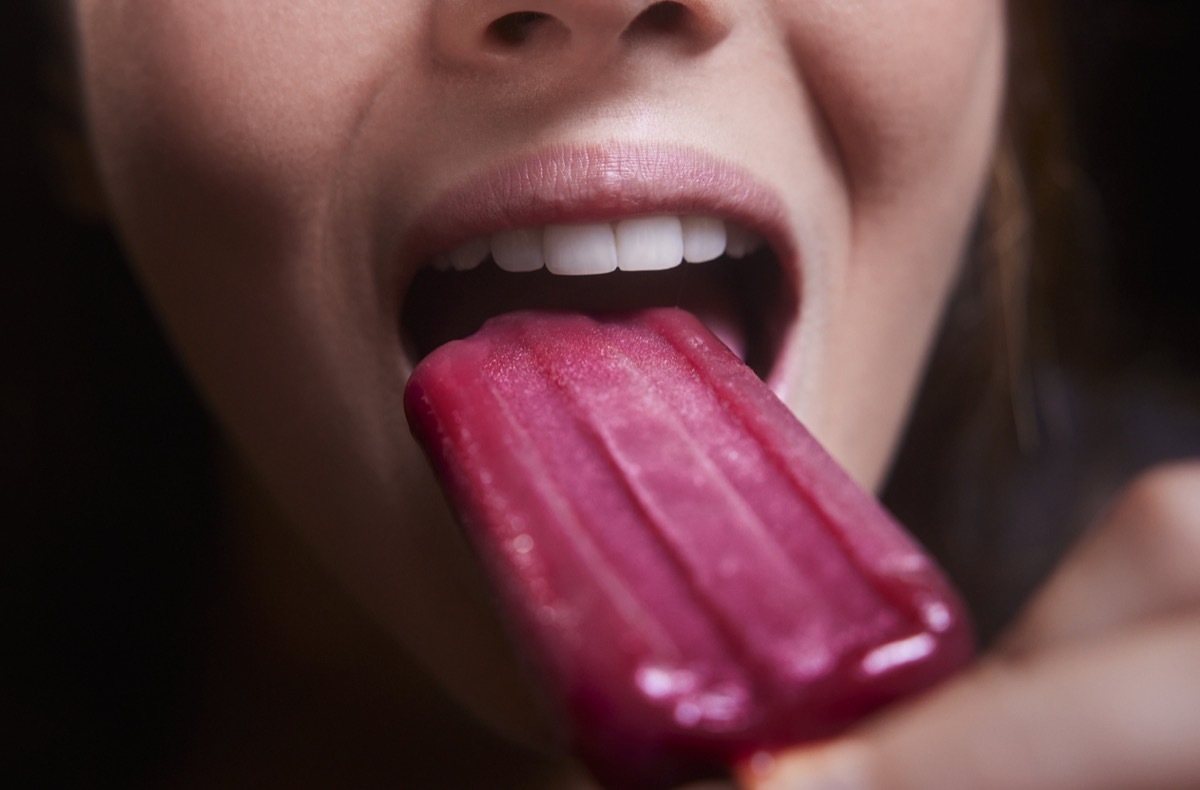 Close-up of young woman mouth red berry popsicle ice cream