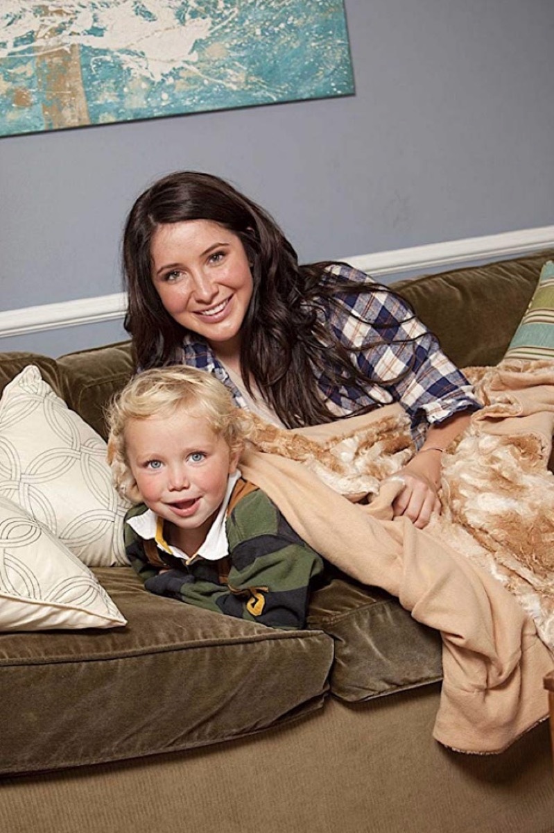 bristol palin and young blond child on green couch under a brown faux fur blanket