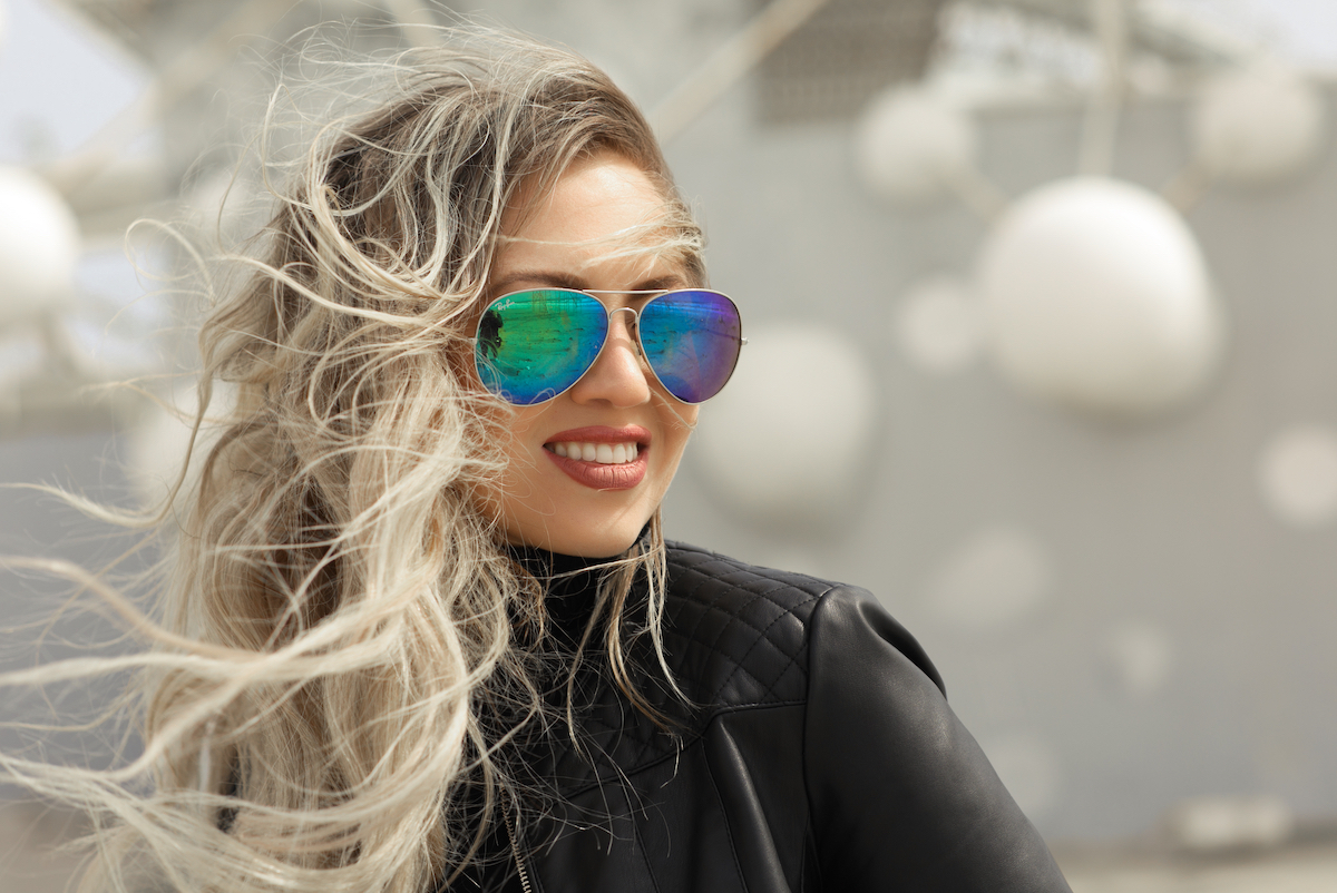 portrait of a young blond woman in aviator sunglasses and a black leather jacket