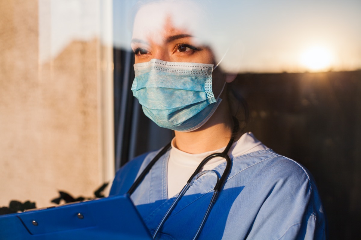 Female doctor in mask with clipboard