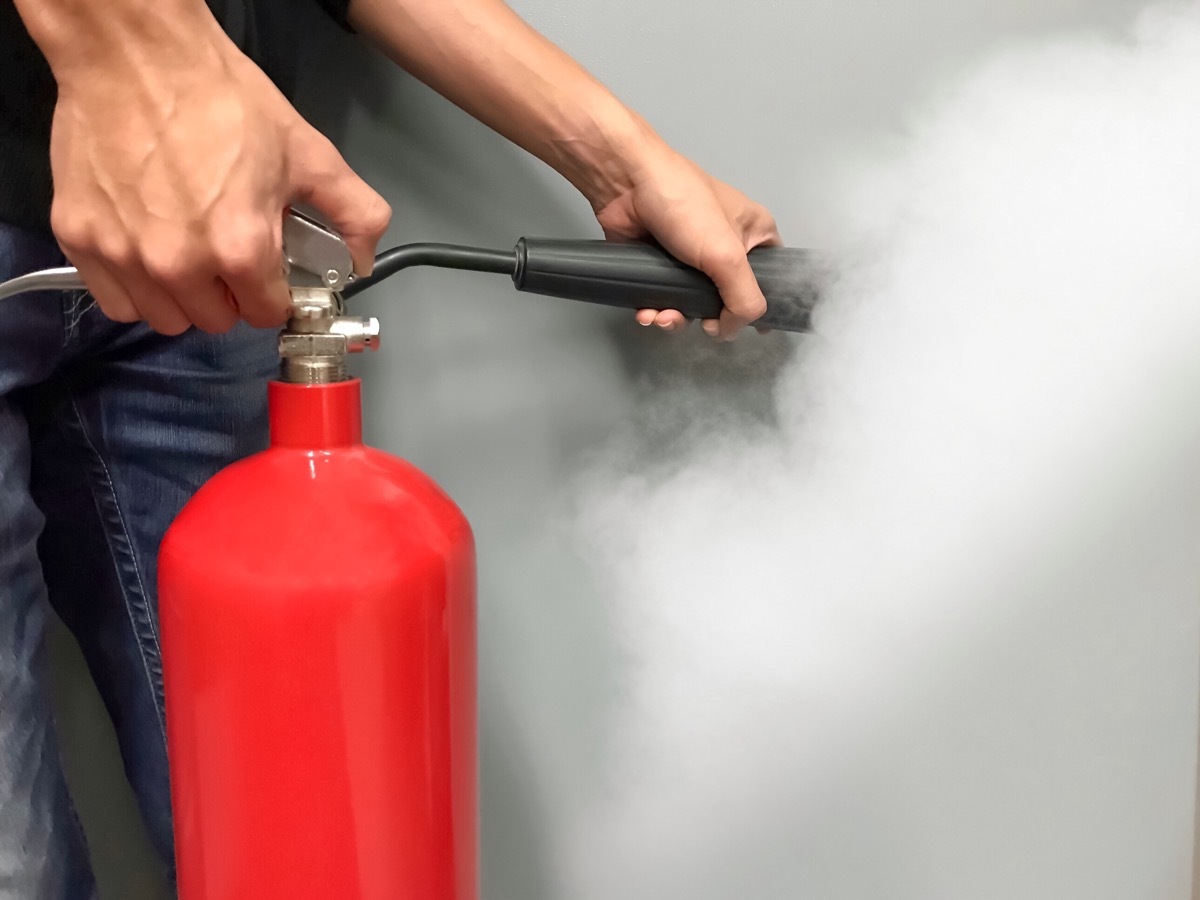 person using fire extinguisher