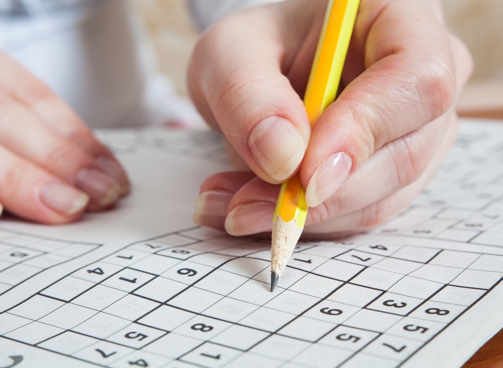 Person completing Sudoku puzzle